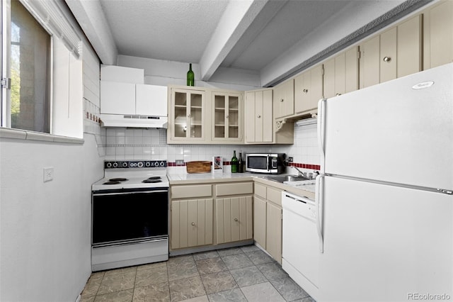 555 E 10th Ave Unit 15, Denver, CO 80203 - kitchen with white appliances, cream cabinetry, light countertops, under cabinet range hood, and tasteful backsplash