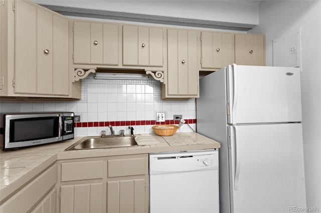 555 E 10th Ave Unit 15, Denver, CO 80203 - kitchen featuring white appliances, cream cabinetry, a sink, tile countertops, and tasteful backsplash