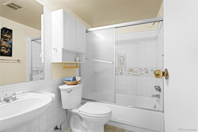 555 E 10th Ave Unit 15, Denver, CO 80203 - bathroom with a sink, toilet, enclosed tub / shower combo, and tile walls