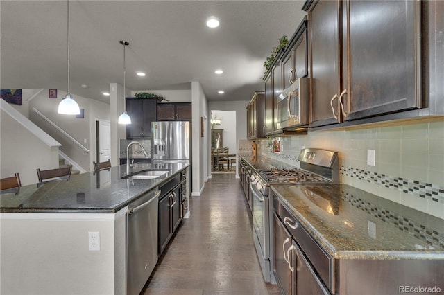 9476 Juniper Way, Arvada, CO 80007 - kitchen with stainless steel appliances, decorative backsplash, dark stone counters, dark wood-type flooring, and recessed lighting