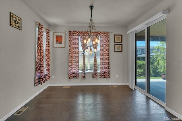 9476 Juniper Way, Arvada, CO 80007 - unfurnished dining area featuring a chandelier, healthy amount of natural light, and dark wood-style flooring