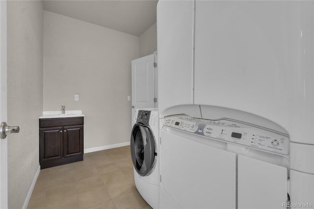 9476 Juniper Way, Arvada, CO 80007 - laundry area featuring washing machine and clothes dryer, cabinet space, and light tile patterned floors