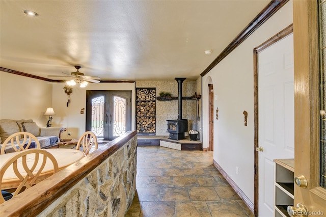 130 Windwalker Rd, Buena Vista, CO 81211 - foyer entrance with french doors, a ceiling fan, stone finish flooring, a wood stove, and ornamental molding