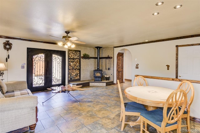 130 Windwalker Rd, Buena Vista, CO 81211 - dining space with arched walkways, ceiling fan, french doors, a wood stove, and crown molding