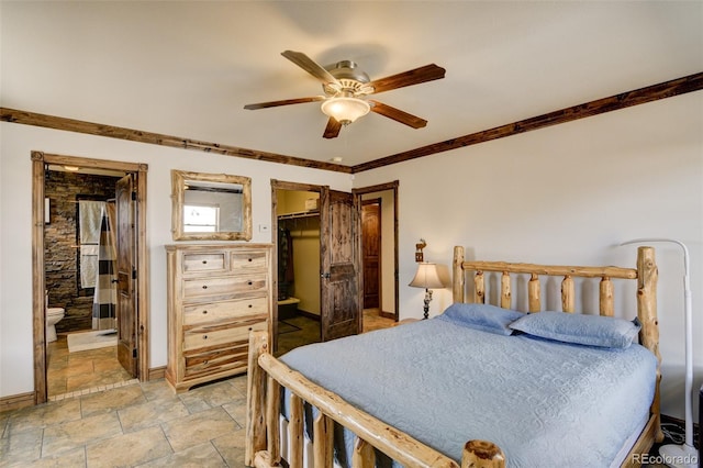 130 Windwalker Rd, Buena Vista, CO 81211 - bedroom with light stone finish flooring, a spacious closet, crown molding, ceiling fan, and connected bathroom
