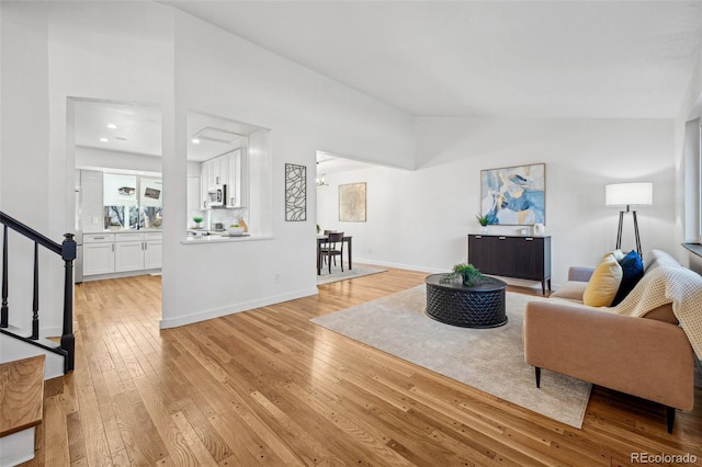 living room with vaulted ceiling and light hardwood / wood-style flooring