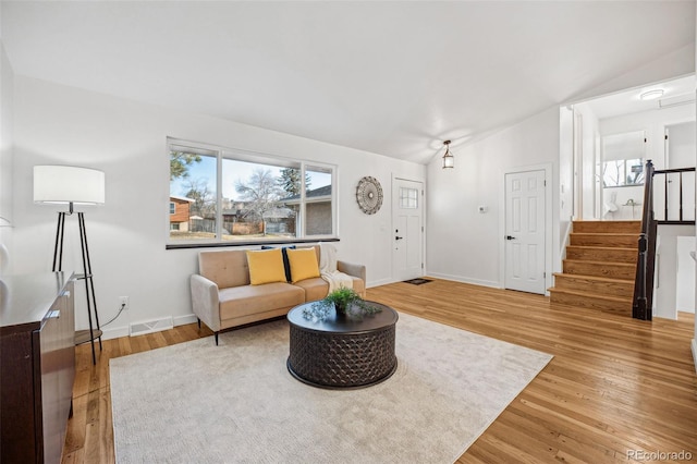 living room featuring vaulted ceiling and wood-type flooring