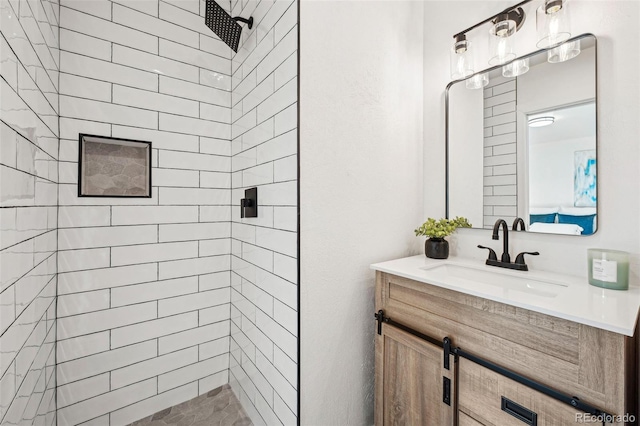 bathroom with vanity and a tile shower