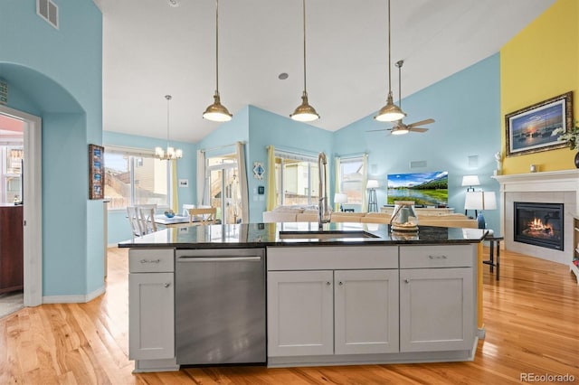 kitchen featuring visible vents, a fireplace, a sink, dishwasher, and open floor plan