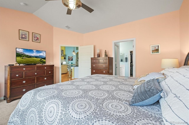 bedroom featuring visible vents, a ceiling fan, ensuite bathroom, light colored carpet, and vaulted ceiling