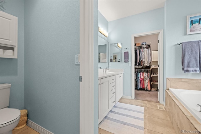 bathroom with vanity, a garden tub, a spacious closet, tile patterned floors, and toilet