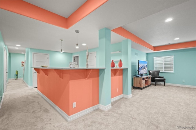 kitchen featuring baseboards, a breakfast bar, recessed lighting, decorative light fixtures, and light colored carpet