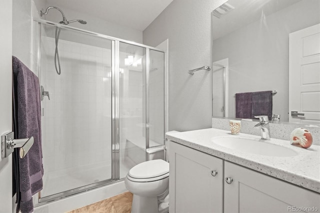 bathroom featuring vanity, toilet, and a shower stall