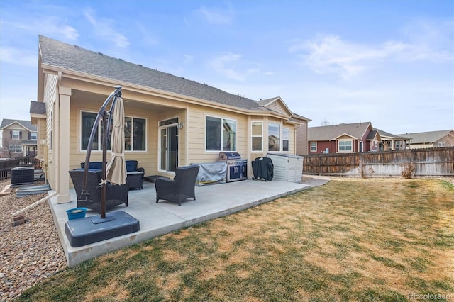 rear view of house featuring an outdoor living space, a patio, a lawn, and a fenced backyard