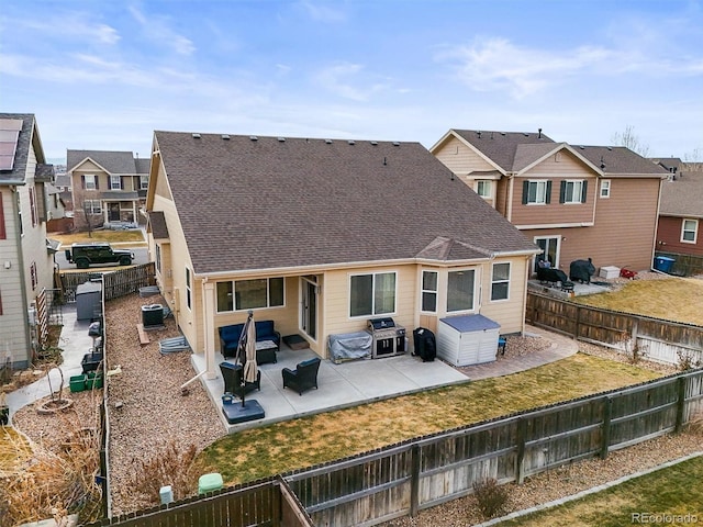 rear view of house with roof with shingles, central AC, a fenced backyard, and a patio area