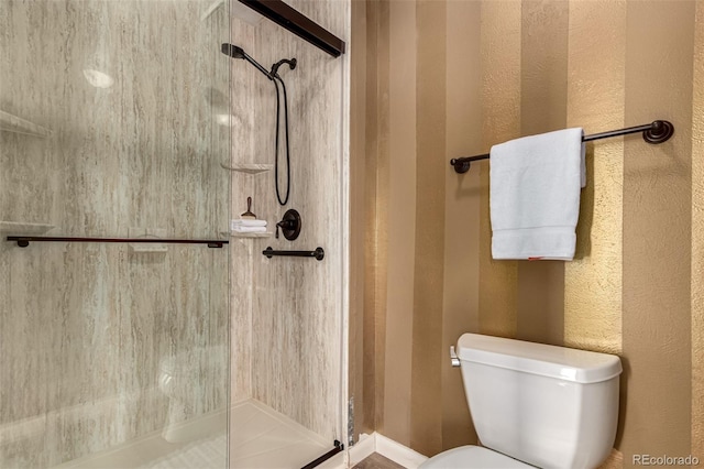 bathroom featuring an enclosed shower and toilet