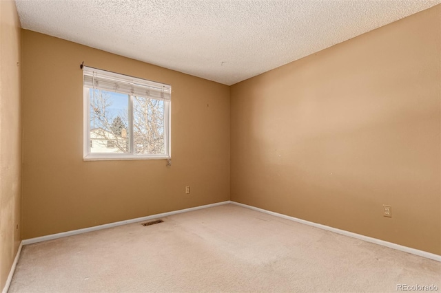 unfurnished room with a textured ceiling and carpet