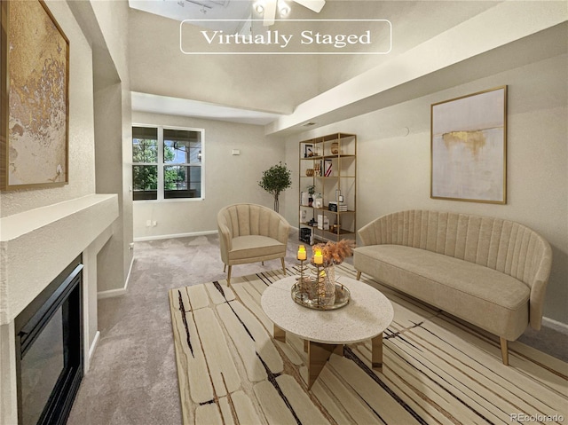 carpeted living room featuring a fireplace and baseboards