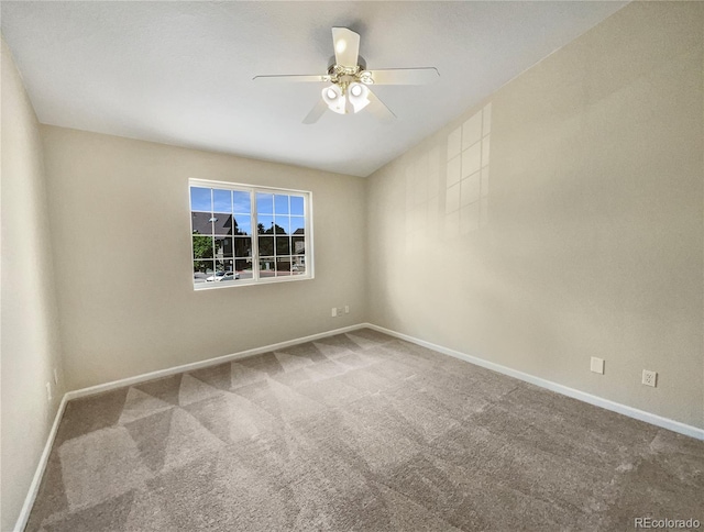 carpeted empty room with ceiling fan and baseboards