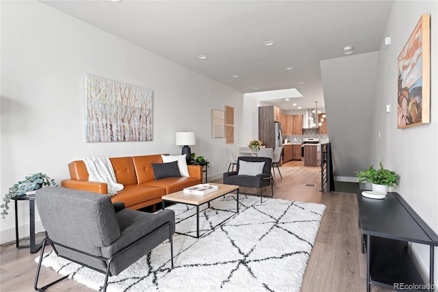 living room featuring light wood finished floors, recessed lighting, and a chandelier