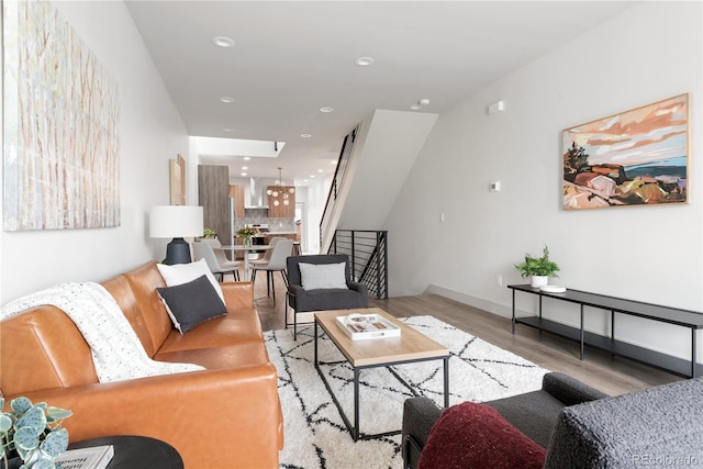 living room featuring wood finished floors, stairs, and recessed lighting