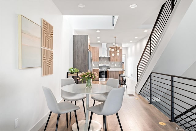 dining area featuring a chandelier, recessed lighting, baseboards, and light wood-style flooring