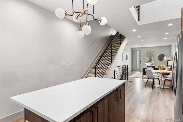 kitchen featuring dark brown cabinetry, recessed lighting, a kitchen island, light countertops, and light wood-style floors