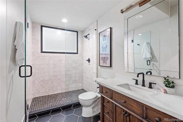 bathroom with a shower stall, tile patterned floors, toilet, vanity, and recessed lighting