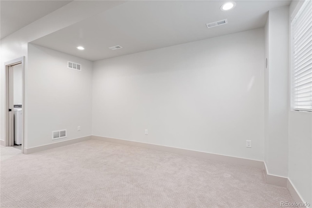 empty room with light carpet, baseboards, and recessed lighting