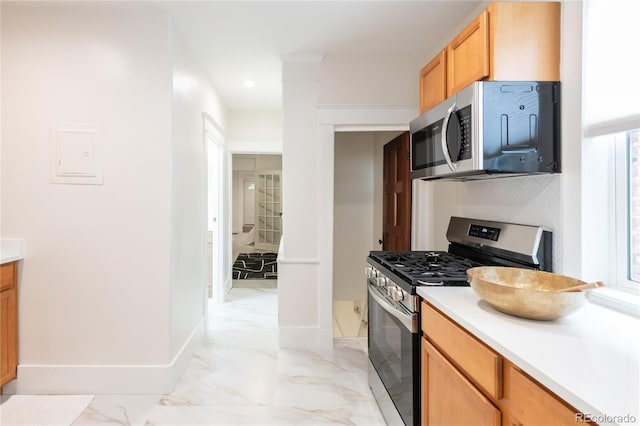 3071 W 38th Ave, Denver, CO 80211 - kitchen featuring appliances with stainless steel finishes, light countertops, baseboards, light marble finish floors, and tasteful backsplash