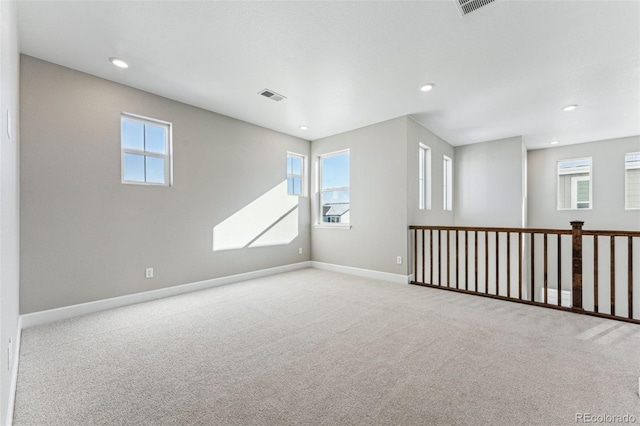 spare room featuring a healthy amount of sunlight and light carpet