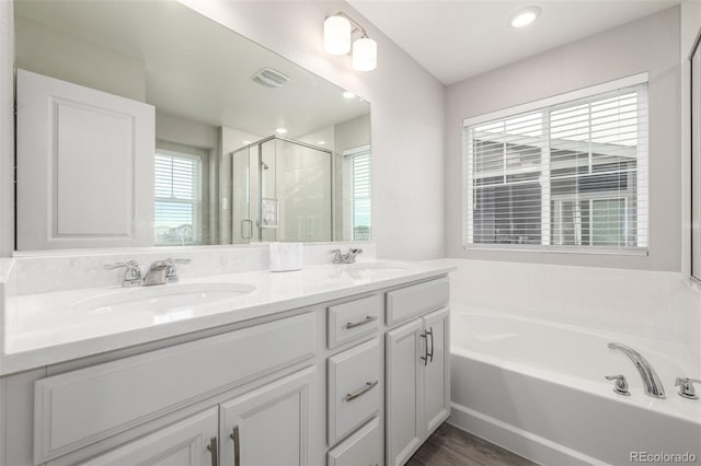 bathroom featuring hardwood / wood-style floors, vanity, and separate shower and tub