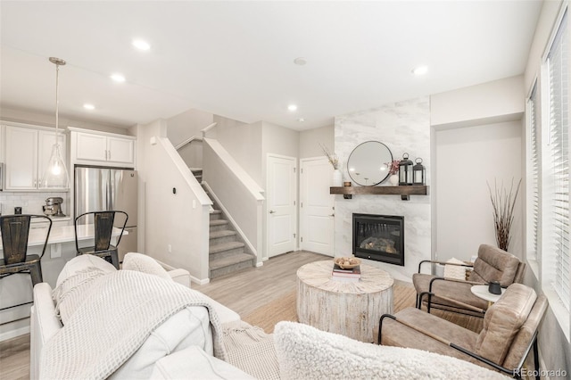 living room featuring a premium fireplace and light wood-type flooring