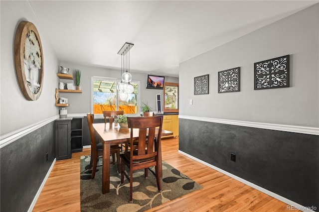 dining area featuring wainscoting and light wood-type flooring