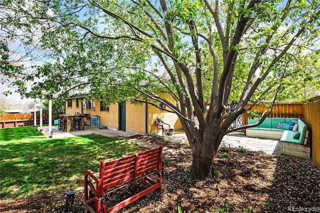 view of yard featuring an outdoor living space, a patio, and a fenced backyard