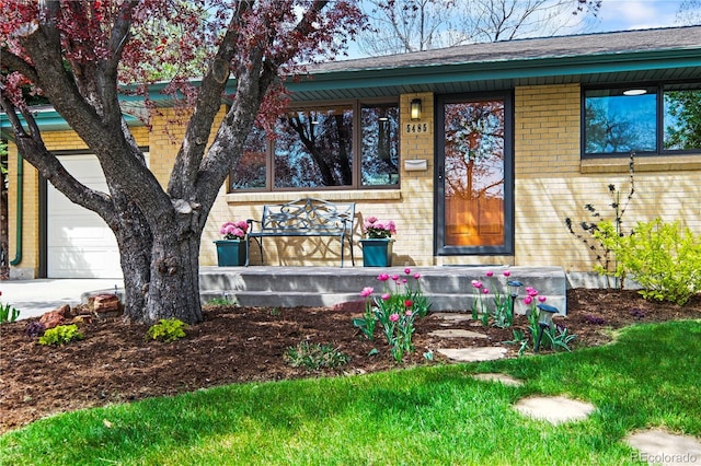 view of front of property featuring brick siding, covered porch, and a garage