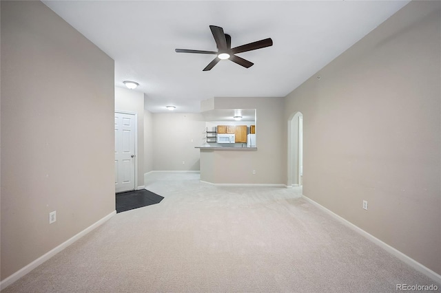 unfurnished living room featuring carpet and ceiling fan