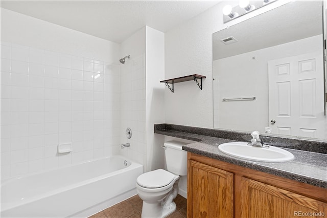 full bathroom with tiled shower / bath, vanity, toilet, and tile patterned floors