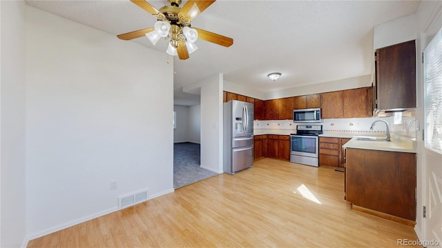 kitchen with visible vents, light countertops, appliances with stainless steel finishes, light wood-type flooring, and tasteful backsplash