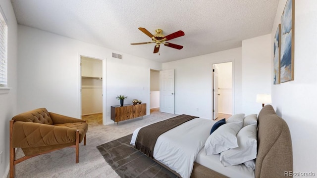 bedroom with carpet, a spacious closet, visible vents, and a textured ceiling