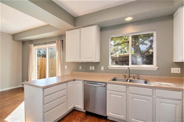 kitchen with a healthy amount of sunlight, stainless steel dishwasher, white cabinetry, and sink