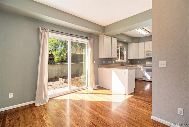 kitchen featuring light wood-type flooring, white appliances, white cabinetry, and sink