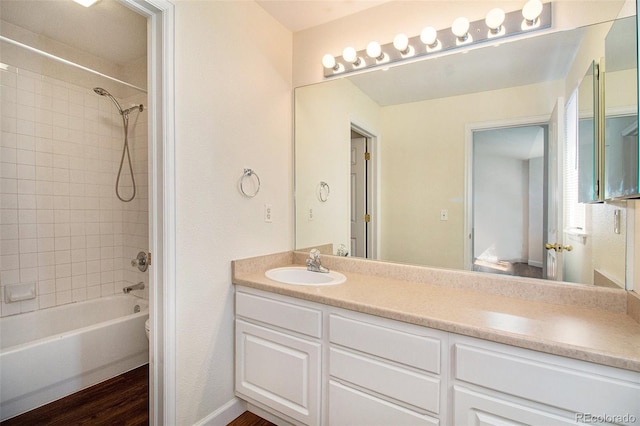 full bathroom with vanity, tiled shower / bath combo, toilet, and hardwood / wood-style flooring