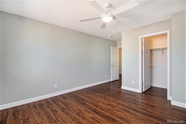 unfurnished bedroom featuring ceiling fan, a closet, dark hardwood / wood-style flooring, and a spacious closet