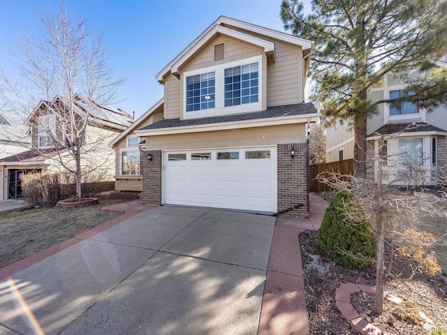 traditional-style home featuring brick siding, roof with shingles, concrete driveway, an attached garage, and fence