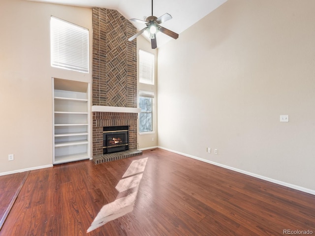 unfurnished living room featuring baseboards, a fireplace, wood finished floors, and built in features