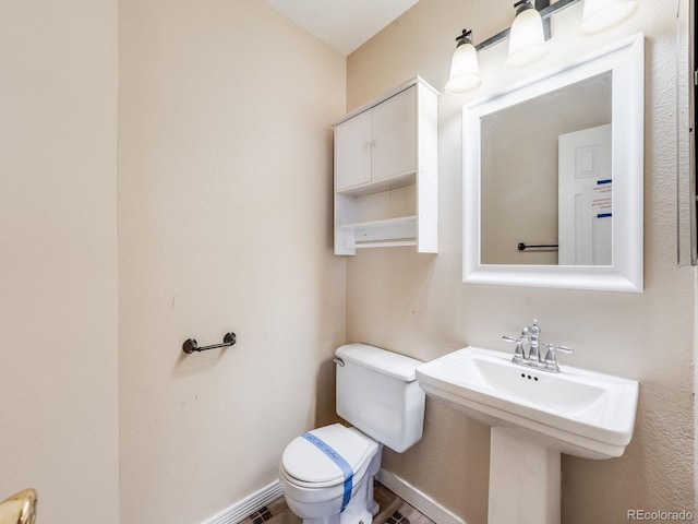 half bath with toilet and baseboards