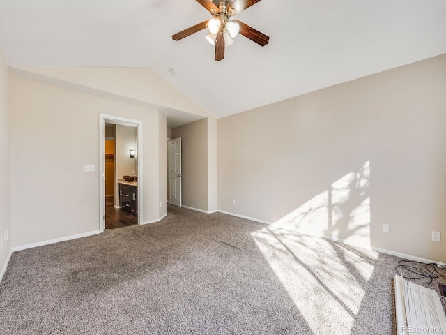 carpeted empty room with lofted ceiling, baseboards, and a ceiling fan