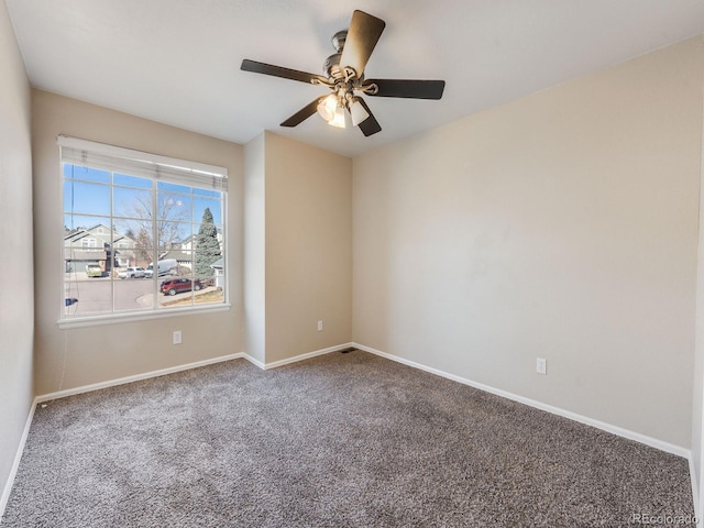 empty room with ceiling fan, carpet floors, and baseboards