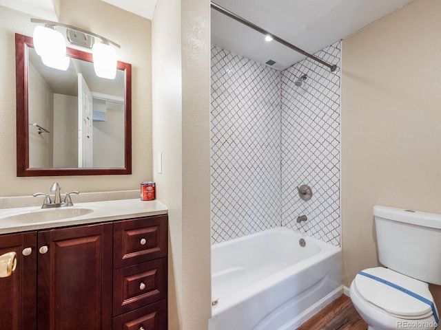 bathroom with toilet, washtub / shower combination, wood finished floors, and vanity